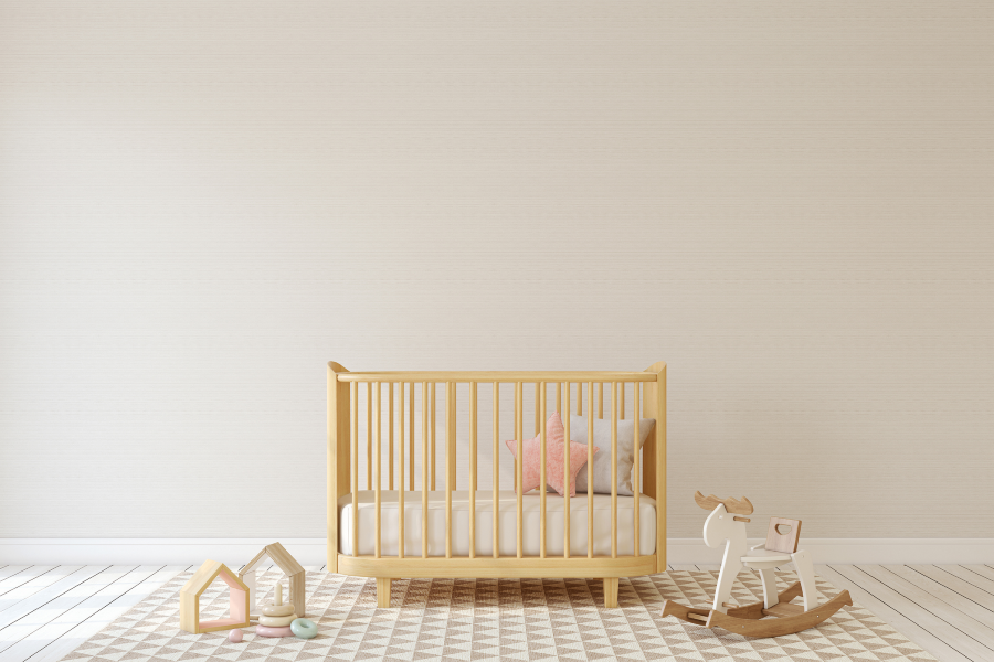 Beige room with crib and kids toys on the floor